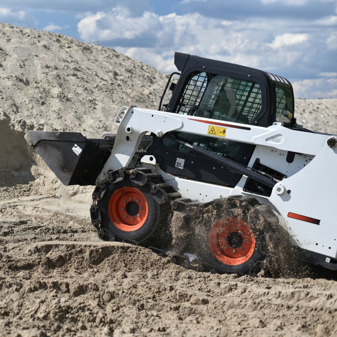 Skid steer driving over rough terrain